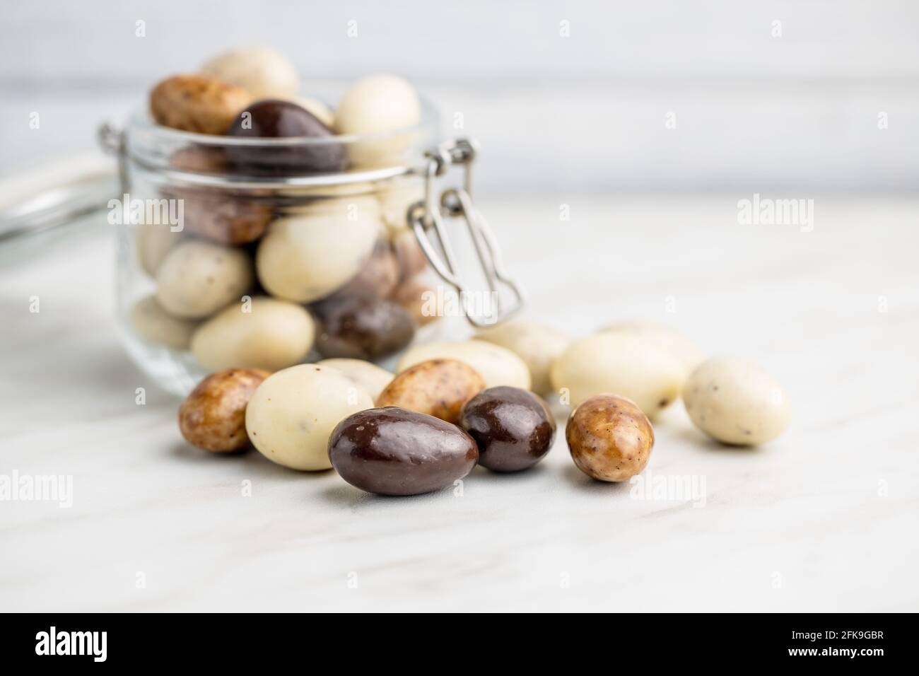 Mandorle dolci al cioccolato. Uova di cioccolato su tavola bianca. Foto Stock