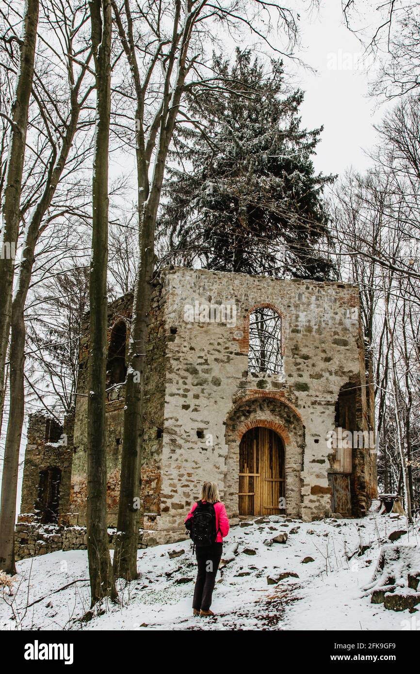 Ragazza escursionistica godendo di vista delle rovine di abbandonata Cappella di Santa Maria Maddalena sulla collina di Maly Blanik, Boemia centrale, ceco Republic.pellegrinaggio Foto Stock
