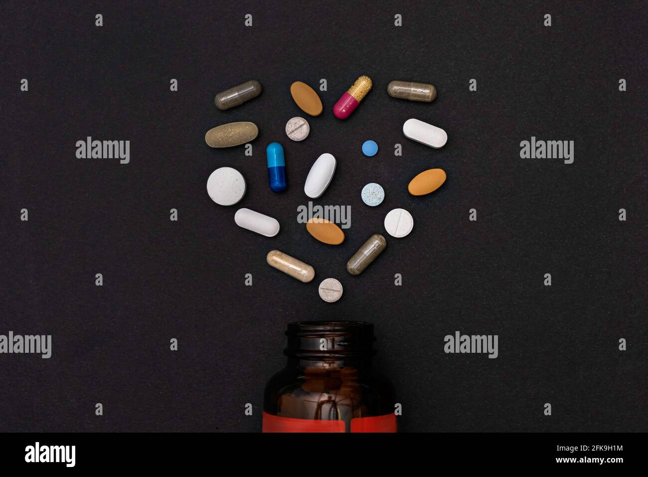 capsule pillole vitamine a forma di cuore e biberon integratori Foto Stock