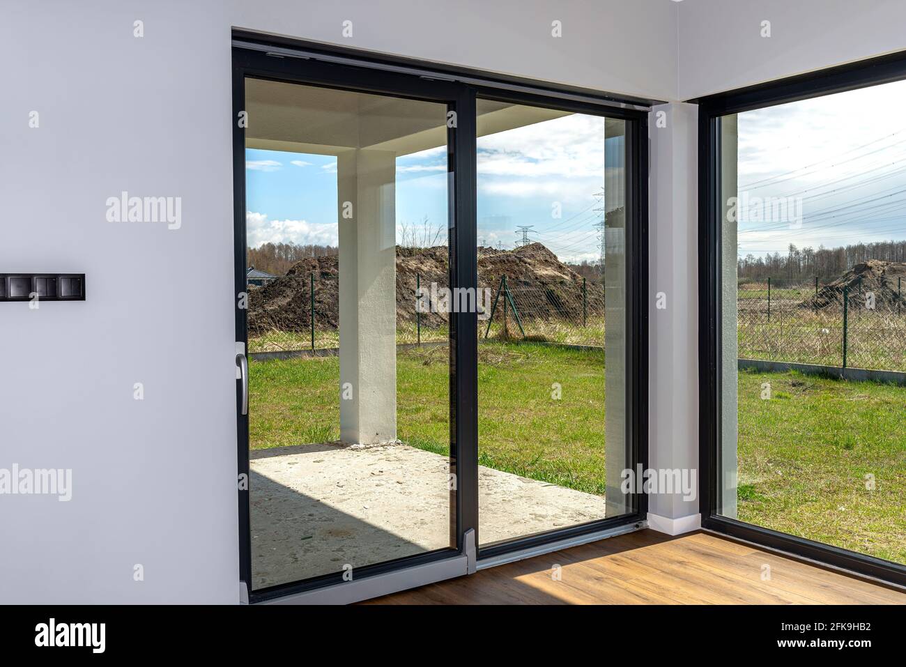 Grandi finestre con terrazza che si affacciano sul giardino, la vista dall'interno del soggiorno sul pavimento sono pannelli in vinile. Foto Stock