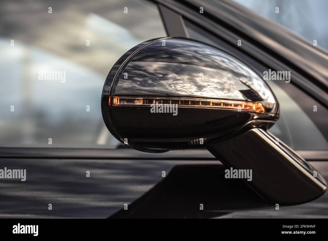 Primo piano dello specchietto laterale destro e del finestrino della carrozzeria nera dell'auto. Settore dei servizi automatici. Sicurezza stradale durante la guida Foto Stock