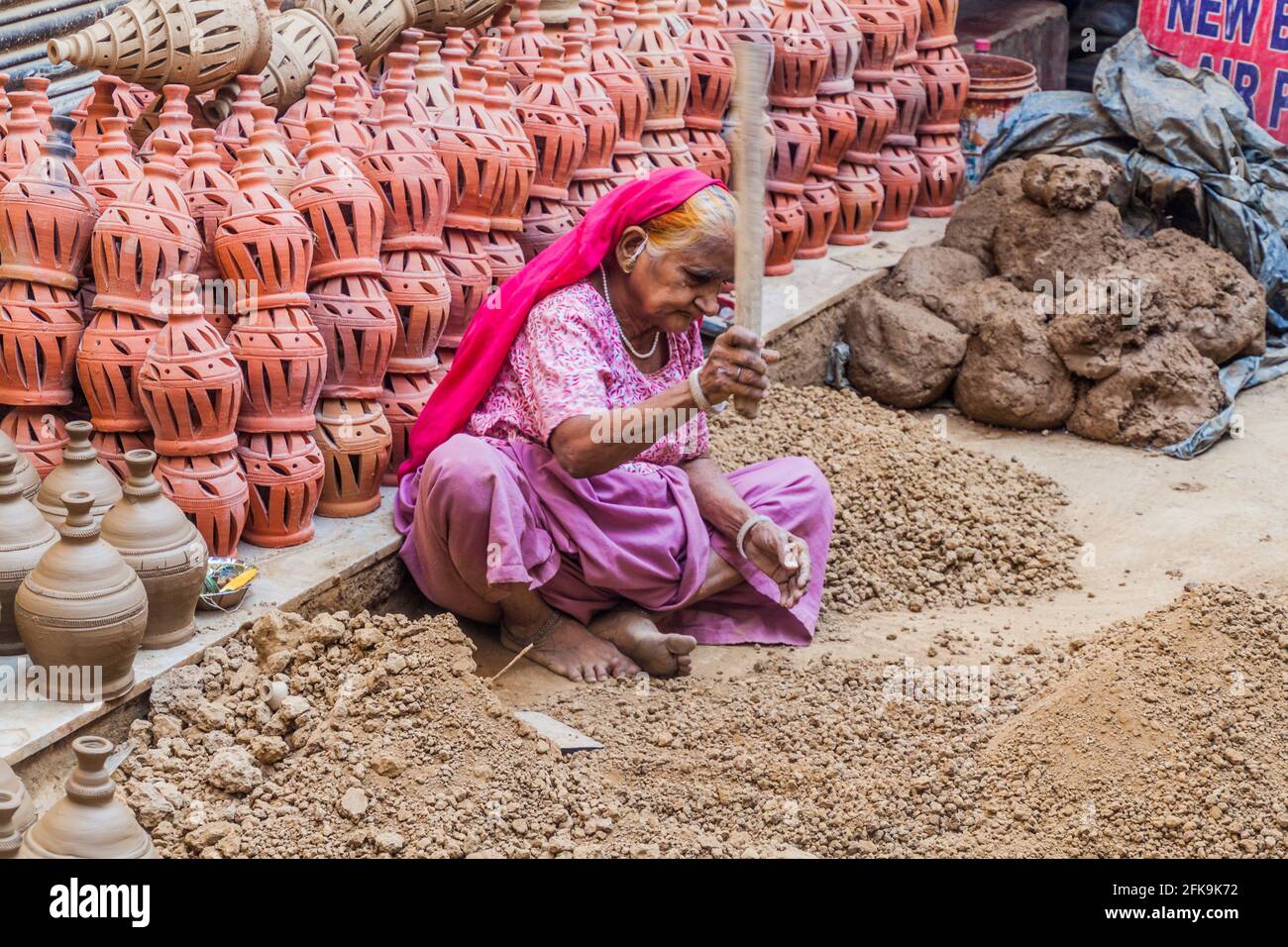 DELHI, INDIA - 22 OTTOBRE 2016: La vecchia donna schiacciando pezzi di argilla nel centro di Delhi, India. Foto Stock