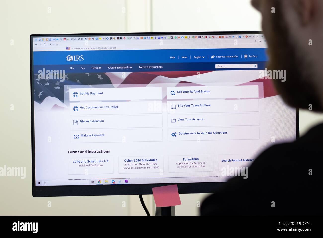 New York, USA - 26 Aprile 2021: Pagina del sito web IRS del Servizio Entrate interne su schermo, uomo che usa il servizio, Editoriale illustrativo Foto Stock