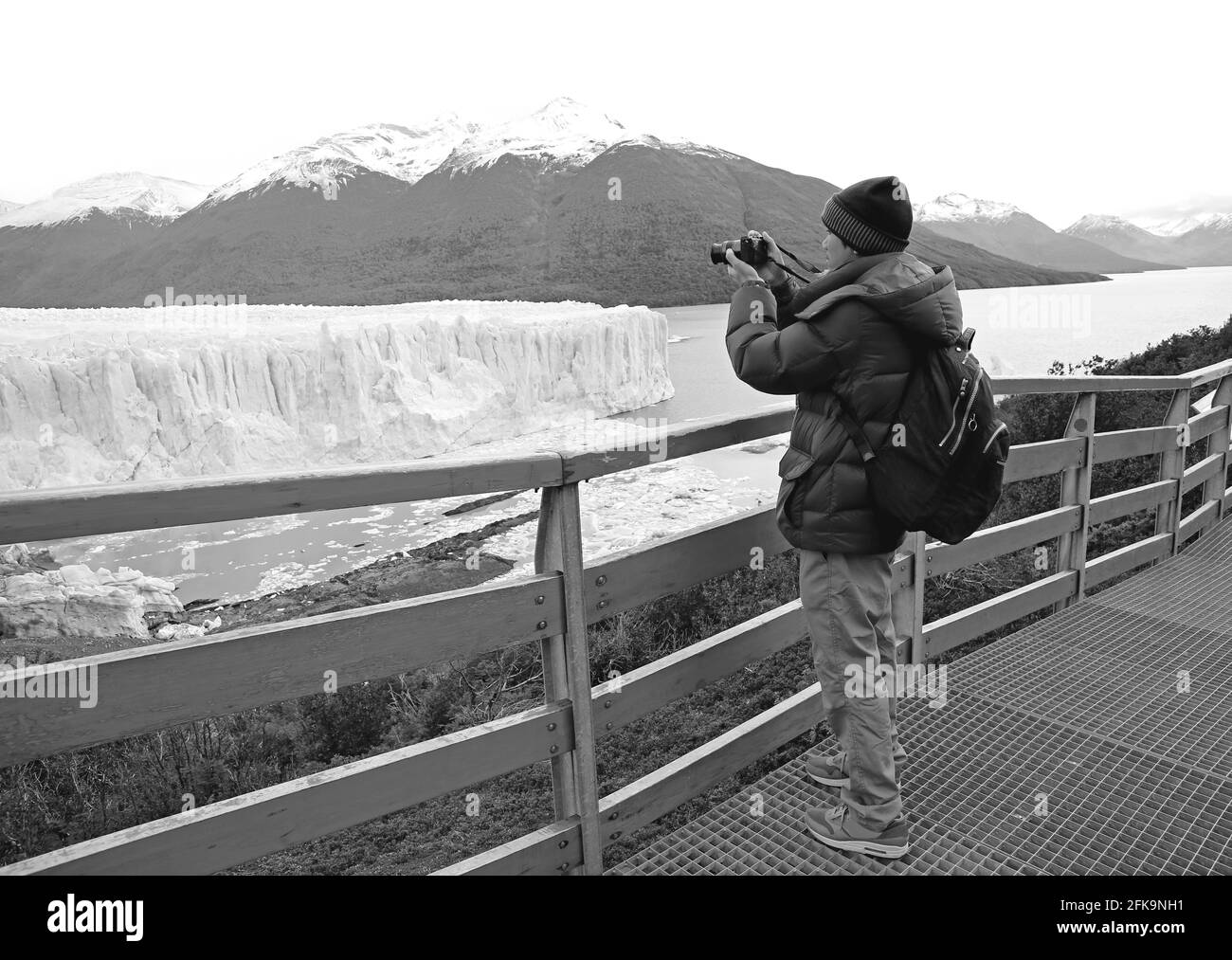 Immagine monocromatica di un viaggiatore scattare foto del ghiacciaio Perito Moreno sulla terrazza panoramica, Los Glaciares National Park, El Calafate, Argentina Foto Stock