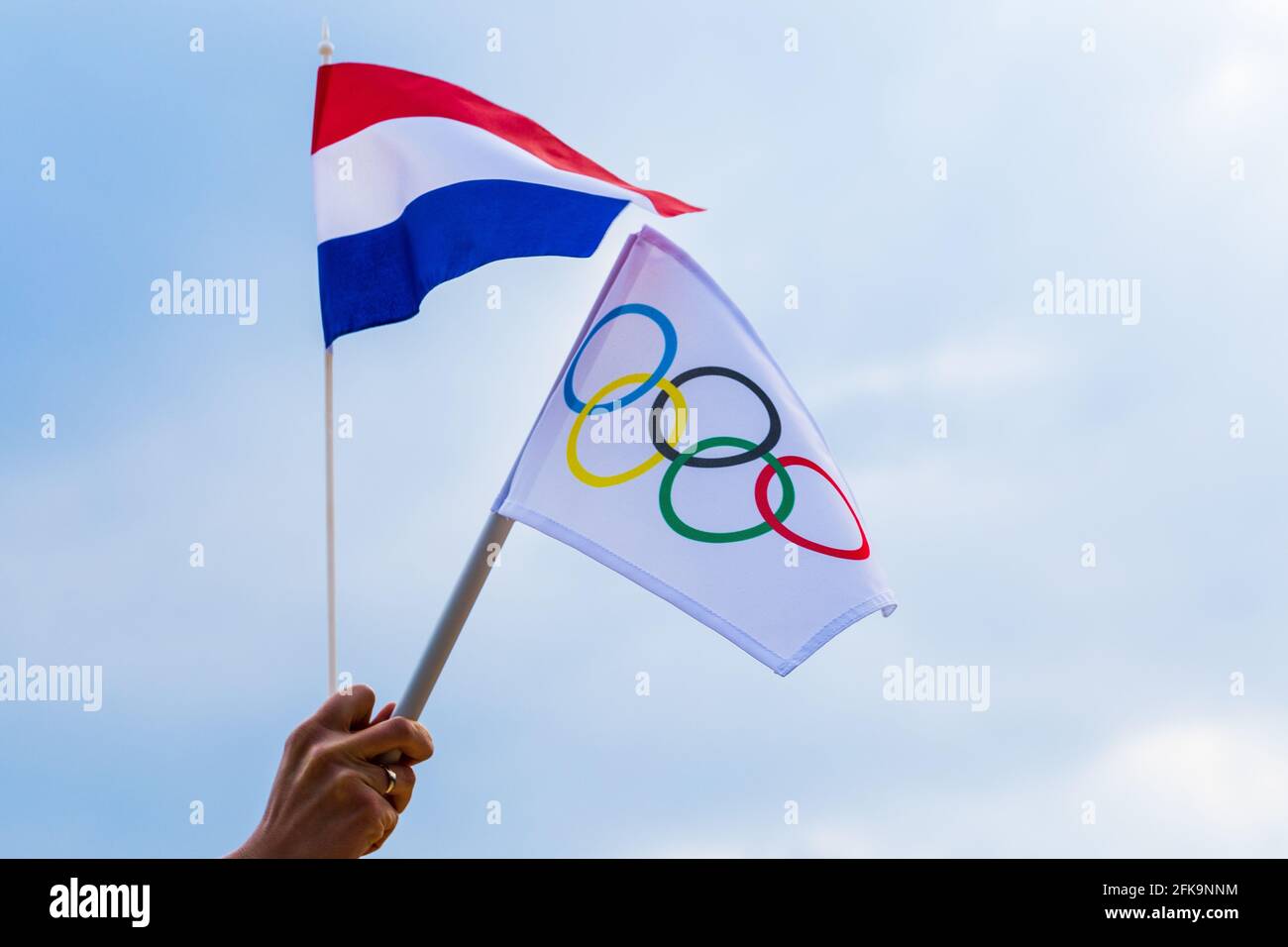 Fan sventolando la bandiera nazionale dei Paesi Bassi e la bandiera olimpica con anelli simbolo olimpiadi. Foto Stock