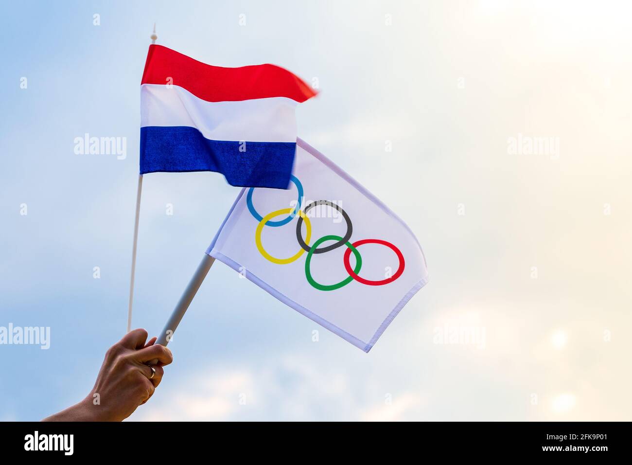 Fan sventolando la bandiera nazionale dei Paesi Bassi e la bandiera olimpica con anelli simbolo olimpiadi. Foto Stock