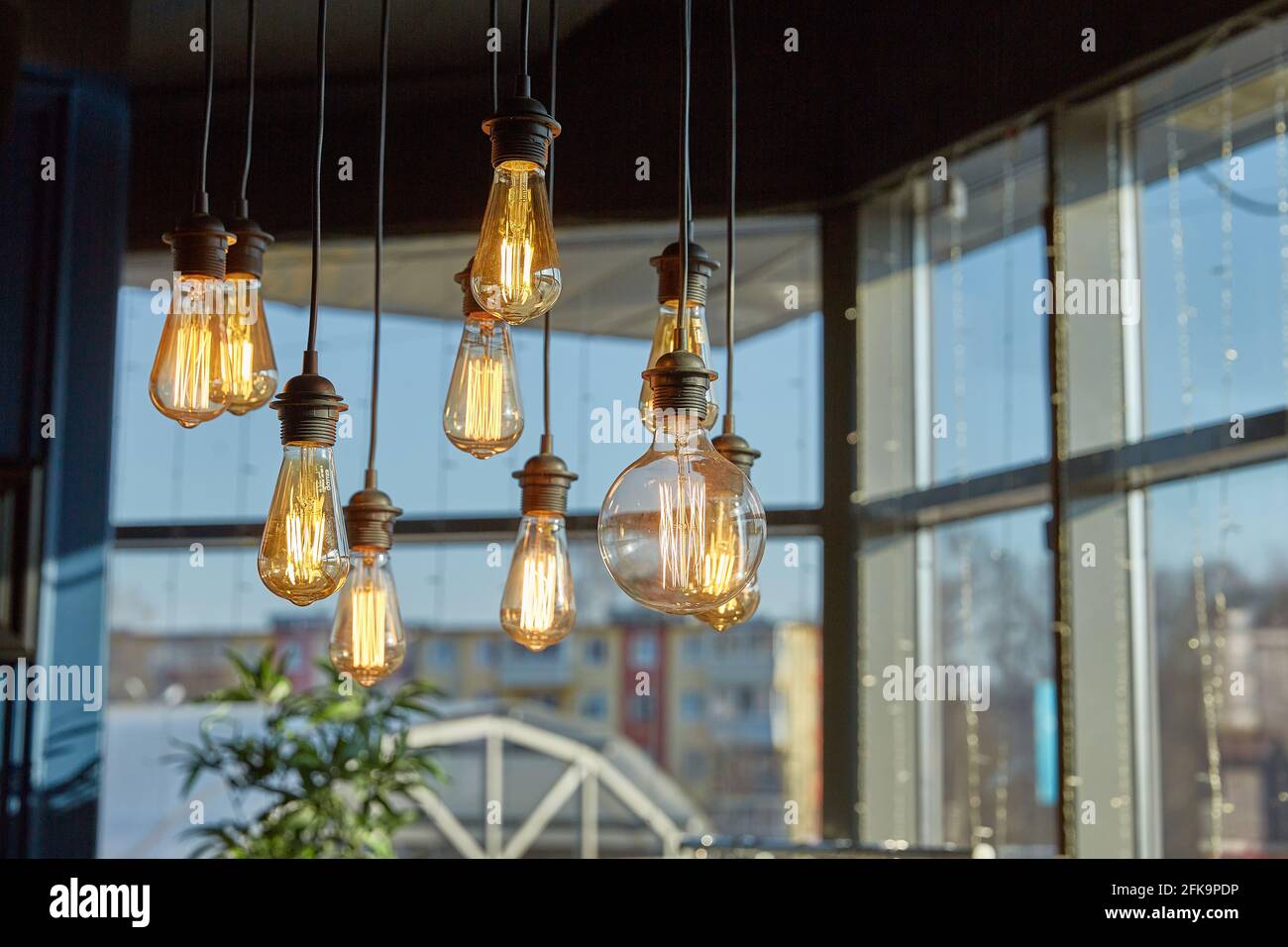 Le lampade decorative da soffitto illuminano una luce soffusa nella foto di una grande finestra. Decorazione della casa ed elementi interni Foto Stock