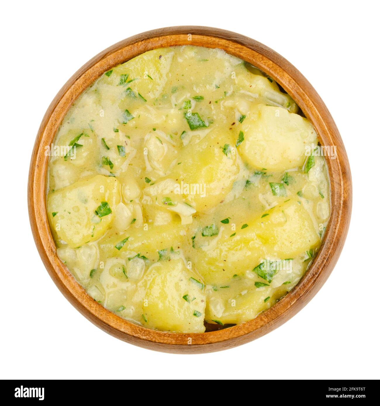 Insalata di patate con olio e aceto in ciotola di legno. Contorno tradizionale tedesco e austriaco a base di patate bollite, olio, aceto, cipolla e prezzemolo. Foto Stock