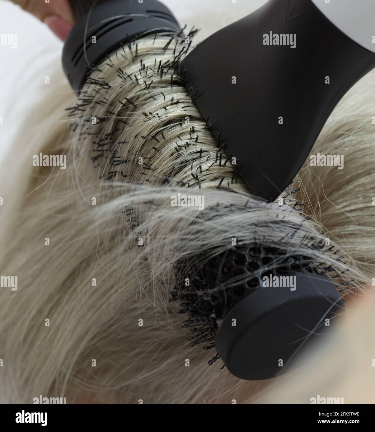 Le mani del parrucchiere invisibile rendono la modella acconciatura Foto Stock