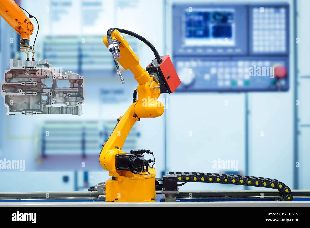 Robot di saldatura in movimento e presa robot lavorare con parti del motore su sfondo di colore blu sfumato, concetto industriale 4.0 Foto Stock