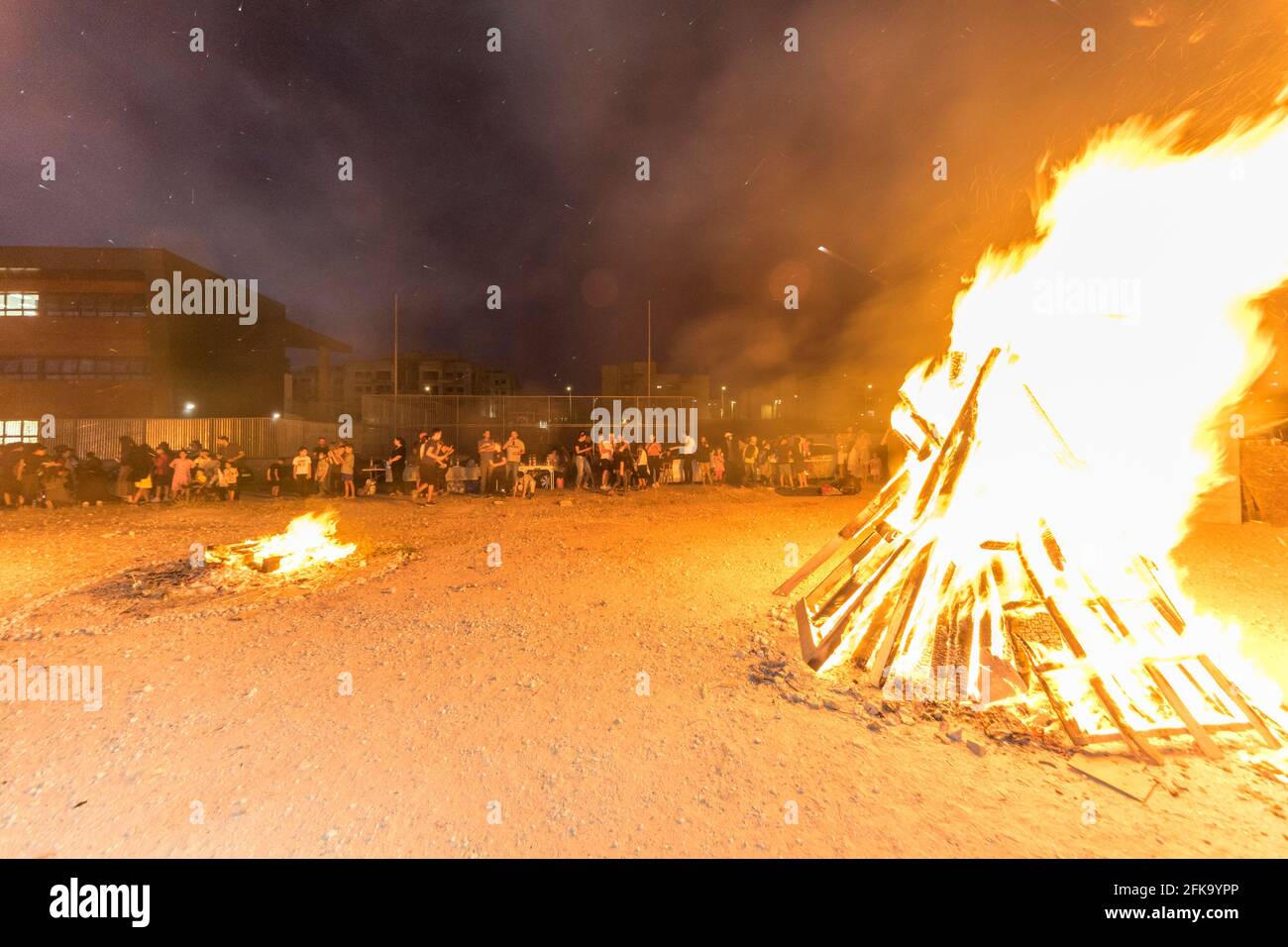 Una grande pira brucia durante la festa ebraica di Lag Ba'Omer, che si svolge ogni 18 del mese ebraico Iyar. È consuetudine durante questa vacanza fare incendi. Quest'anno, a causa del pericolo di incendio, tutti gli incendi sono stati concentrati in pochi siti, da cui il gran numero di piri, che si può vedere in background. Foto Stock