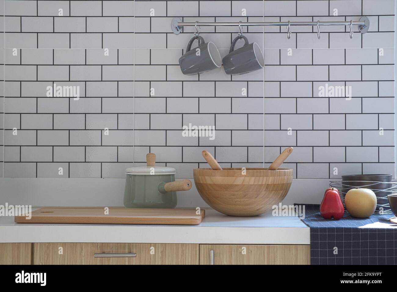 Primo piano cucina con pentola, tritare legno, vasca in legno e due tazze da caffè in ceramica messo su banco moderno, interni e arredamento di casa in stile moderno Foto Stock