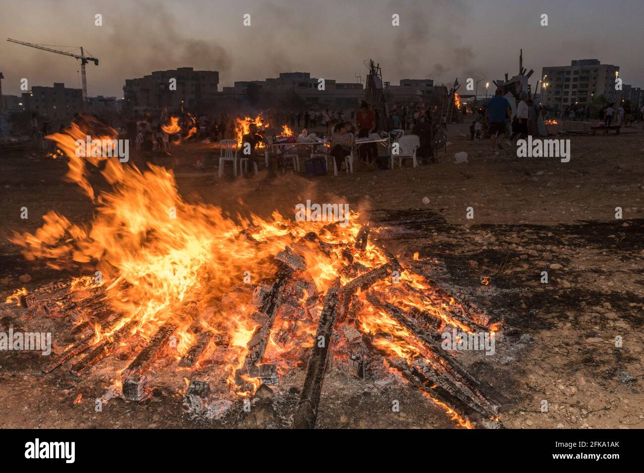 Persone che fanno fuoco durante la festa ebraica di Lag Ba'Omer, che si svolge ogni 18 del mese ebraico Iyar. È consuetudine durante questa vacanza fare incendi. Quest'anno, a causa del pericolo di incendio, tutti gli incendi sono stati concentrati in pochi siti, da cui il gran numero di piri. Foto Stock