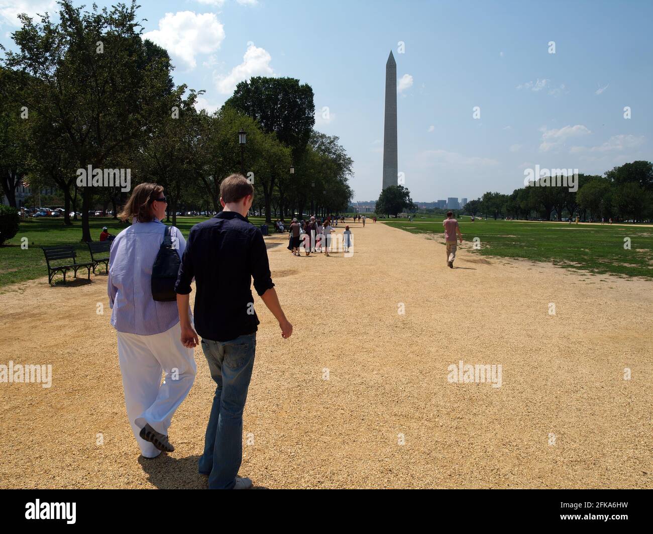 Una donna e un giovane uomo o un figlio adolescente camminano lungo il National Mall verso il Washington Monument in estate. Foto Stock
