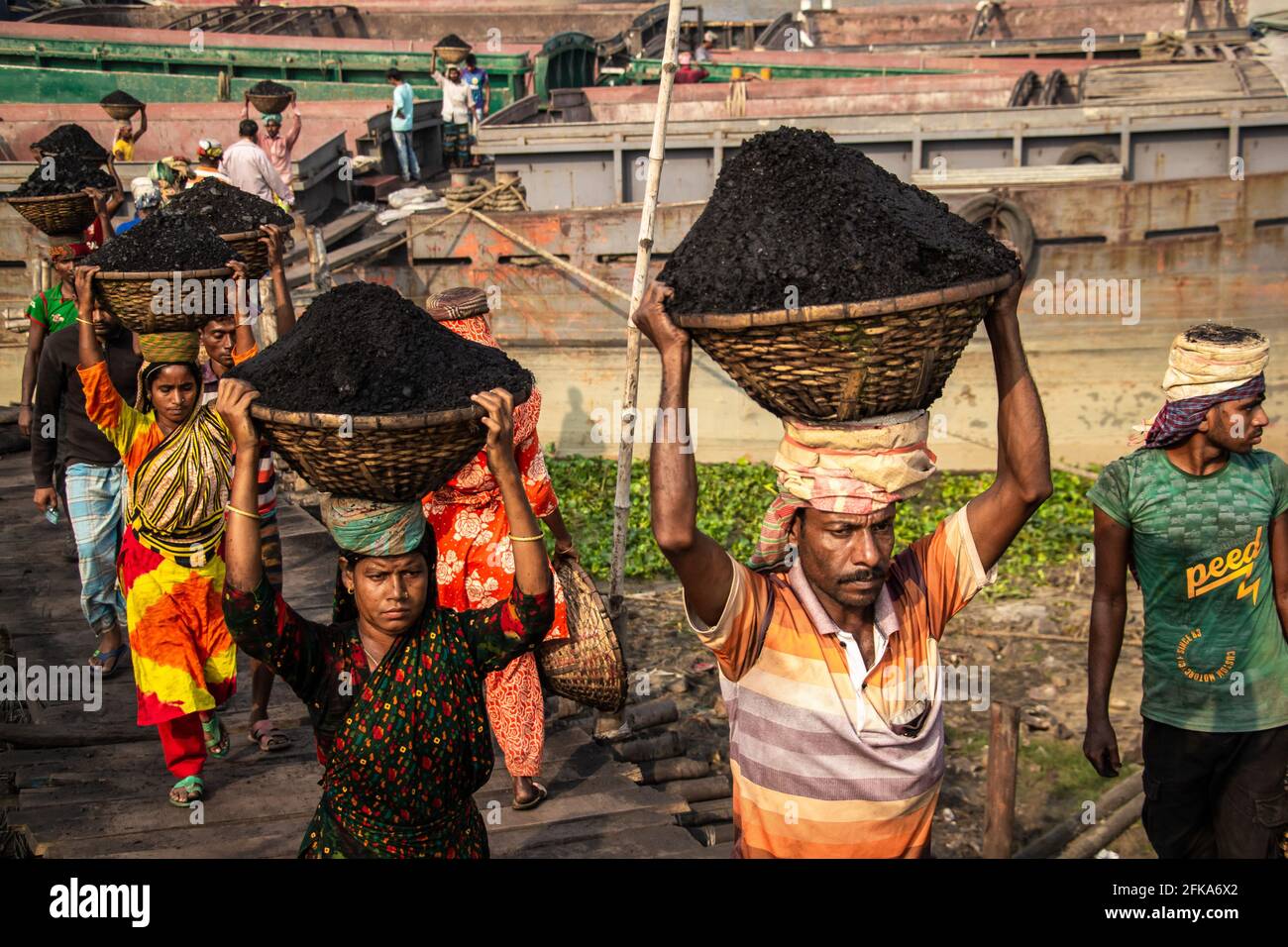 Uomini donne che lavorano duramente in carbone fabbrica ho catturato questa immagine il 17-11-2018 da Amen Bazar, Dhaka, Bangladesh Foto Stock
