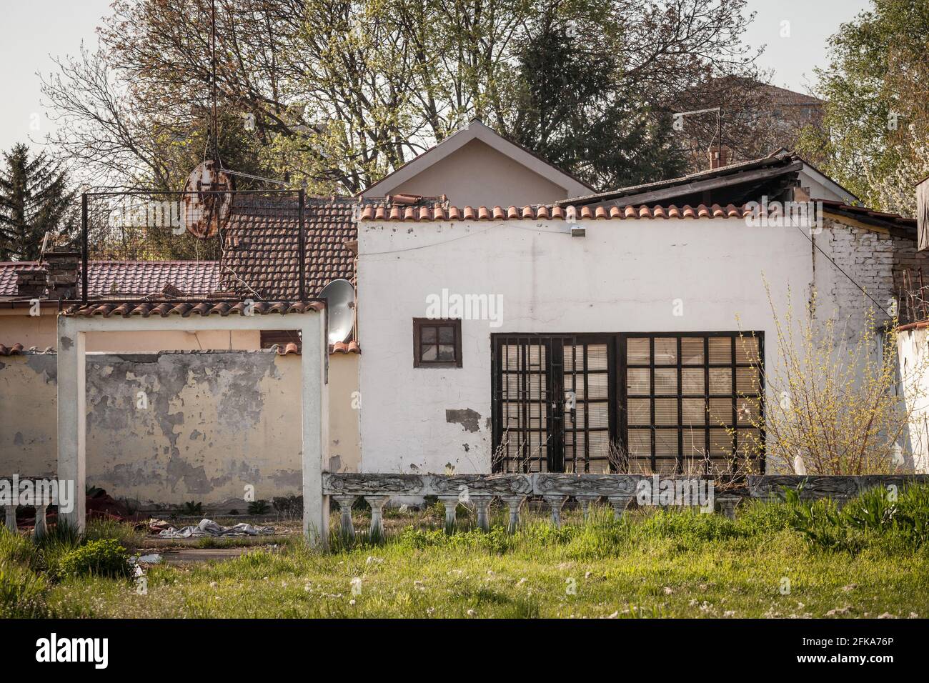 Immagine di un ristorante abbandonato visto durante un pomeriggio soleggiato dall'esterno, con un accento sulla sua terrazza rovinata. Foto Stock