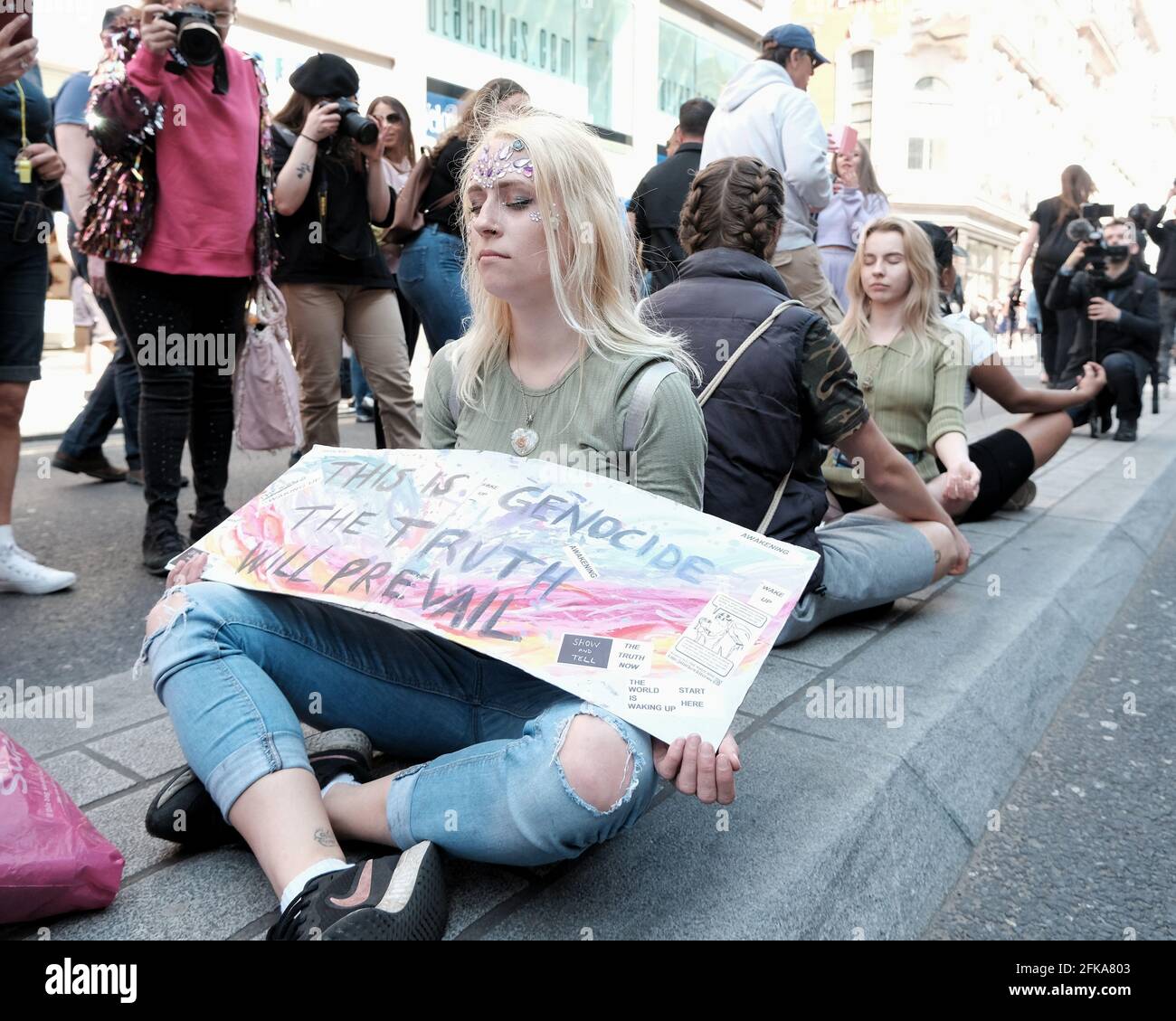 Un gruppo di persone si siede in strada e medita durante la protesta "per la libertà", contro il progetto di passaporto per il vaccino proposto nel Regno Unito. Foto Stock