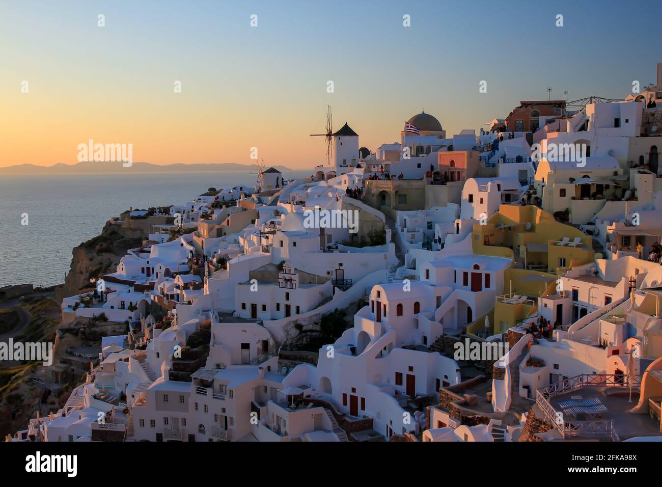 Paesaggio urbano di edifici bianchi a Oia, Santorini, Grecia al tramonto Foto Stock