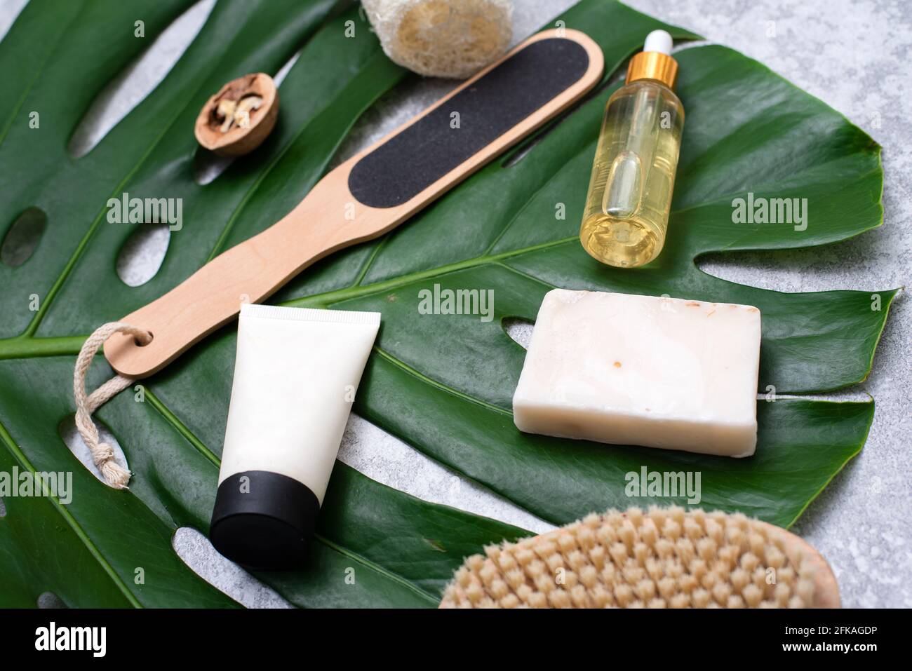 Composizione Spa con prodotti per la cura del corpo e piante su sfondo grigio. Vista dall'alto. Foto Stock