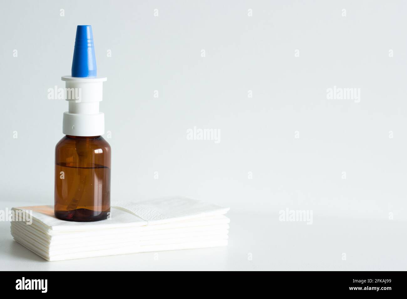 Spray nasale in flacone marrone con tappo blu su bianco sfondo Foto Stock