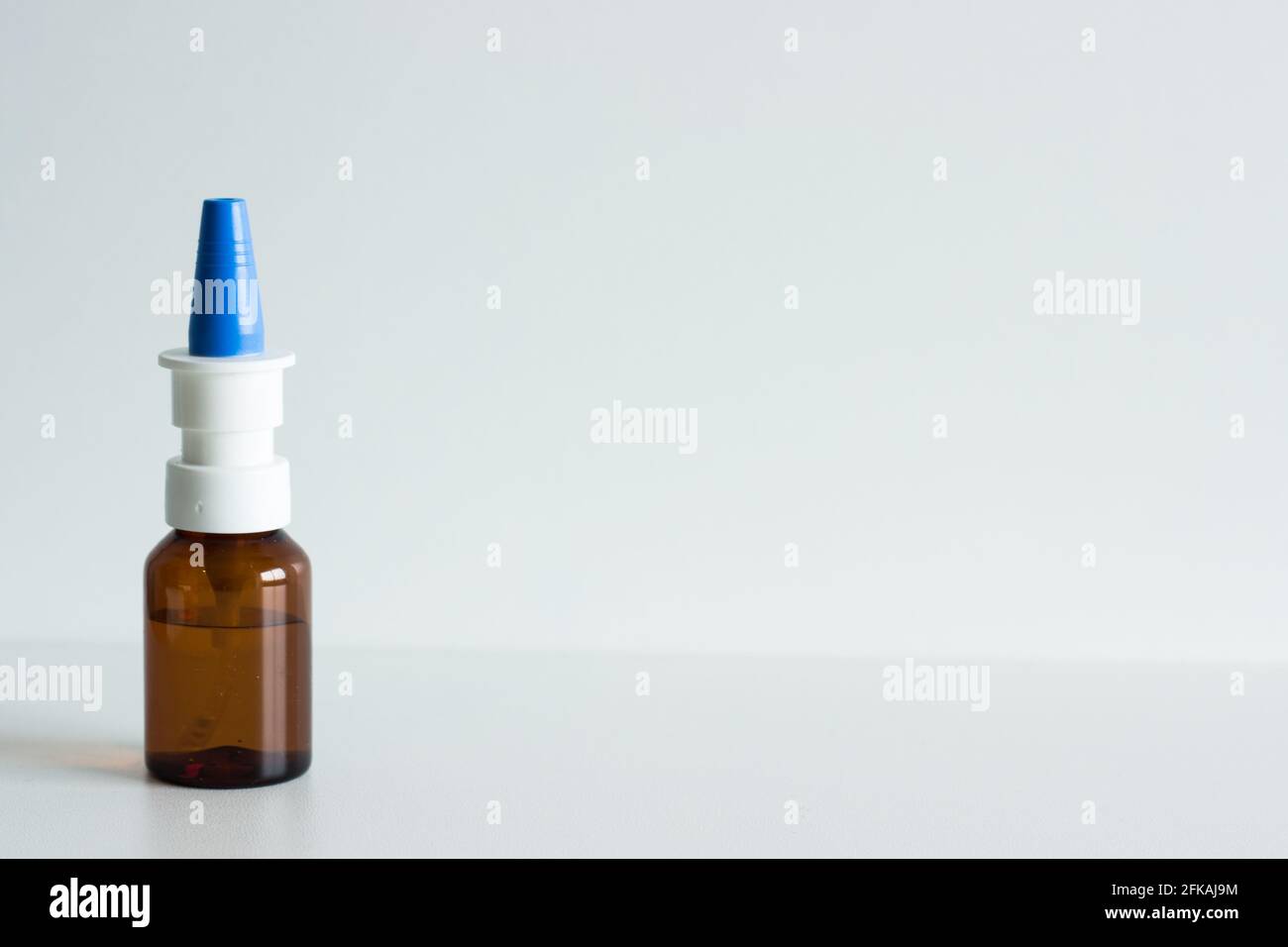 Spray nasale in flacone marrone con tappo blu su bianco sfondo Foto Stock