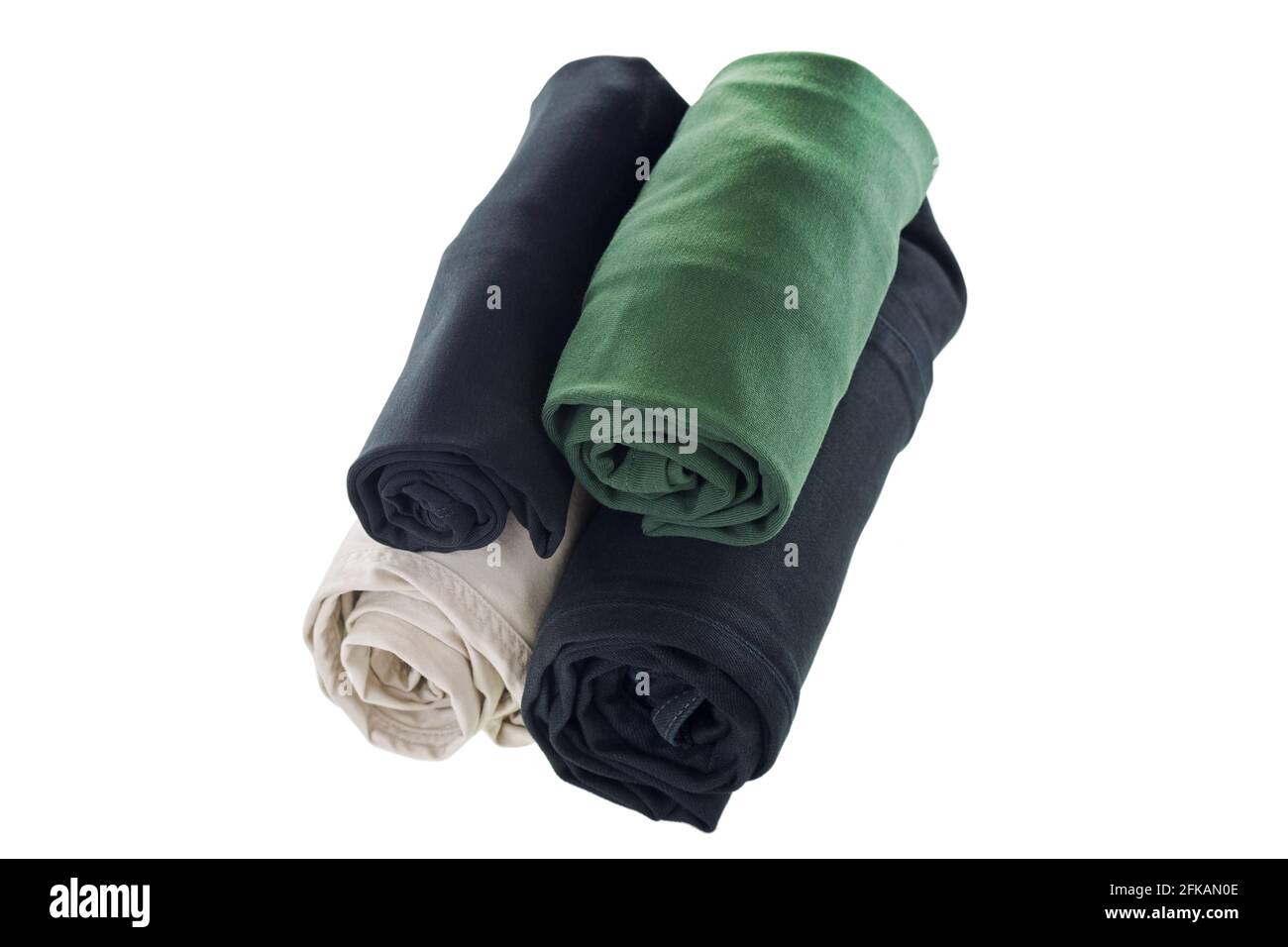 Pila di vestiti arrotolati, t-shirt, pantaloni, jeans neri isolati su sfondo bianco Foto Stock