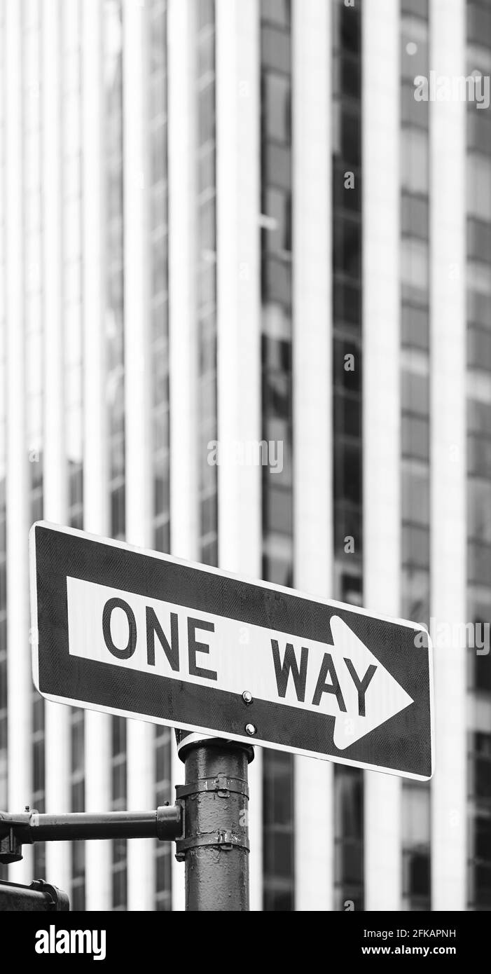 Immagine in bianco e nero di un segnale di traffico a senso unico con edificio offuscato in background, fuoco selettivo, New York City, USA. Foto Stock