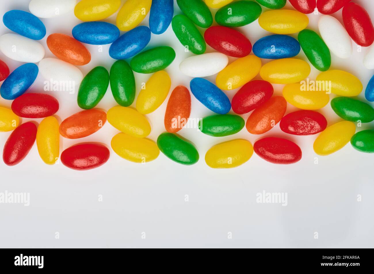 Caramelle ovali gialle e blu con spazio per la copia da studio bianco Foto Stock