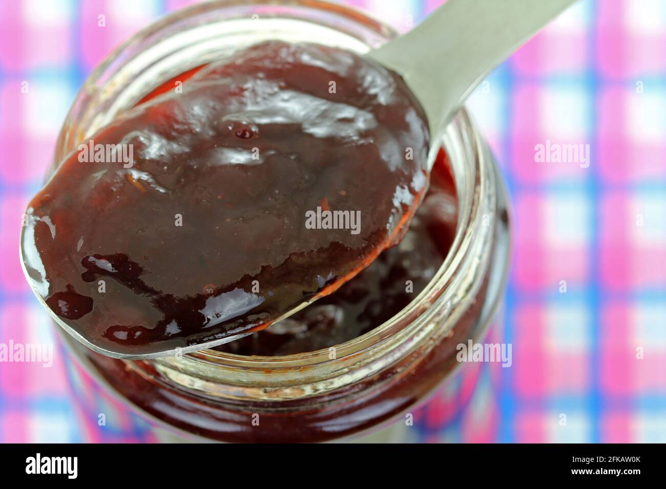 Un vasetto di marmellata di lamponi con timo, isolato su sfondo bianco Foto Stock