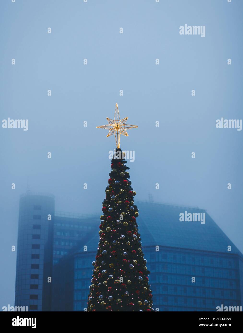 Decorato con splendenti stelle di Natale e baubles sullo sfondo di la città nebbiosa Foto Stock