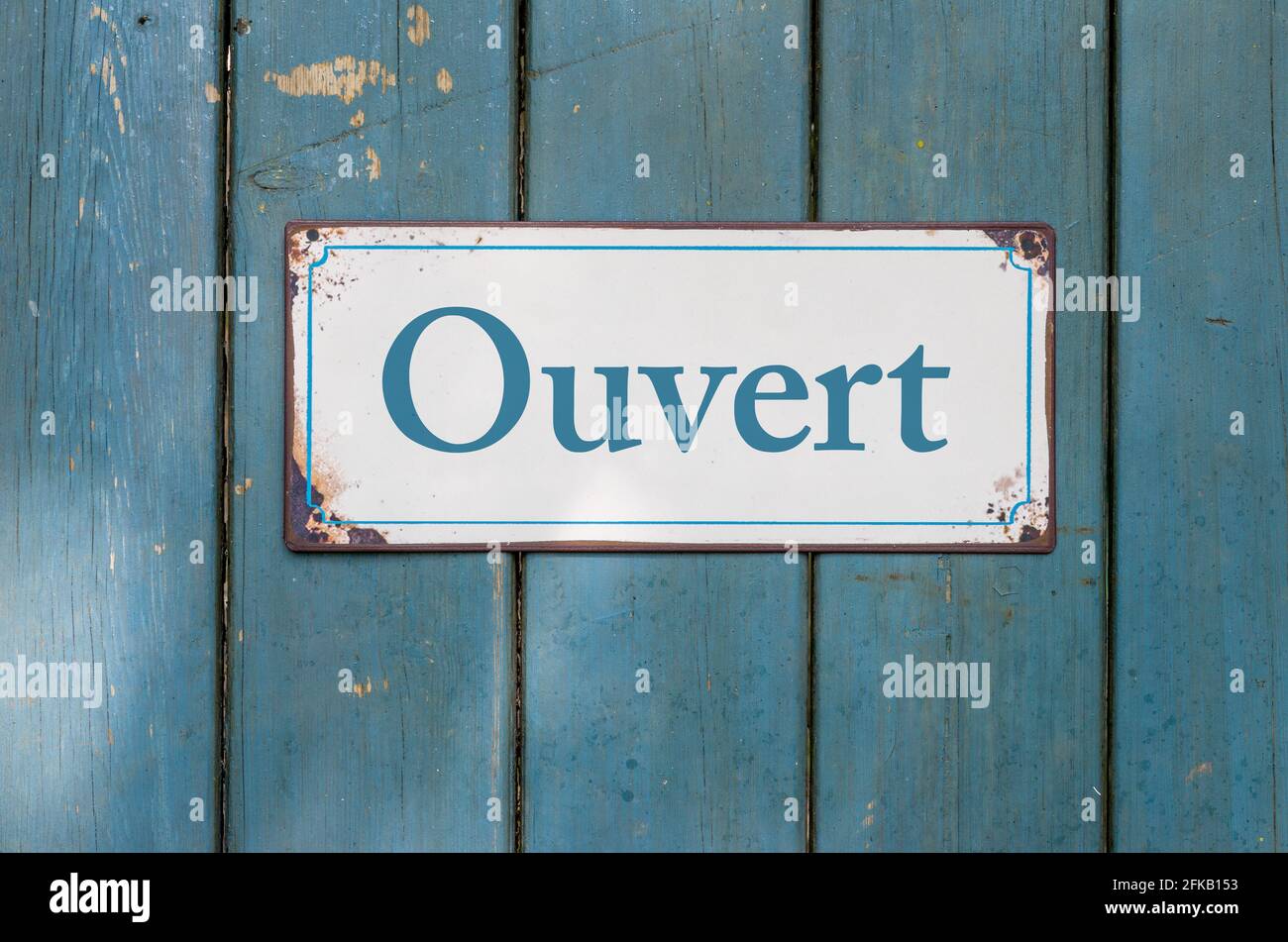 Vecchio segno con l'iscrizione aperto in francese - Ouvert Foto Stock