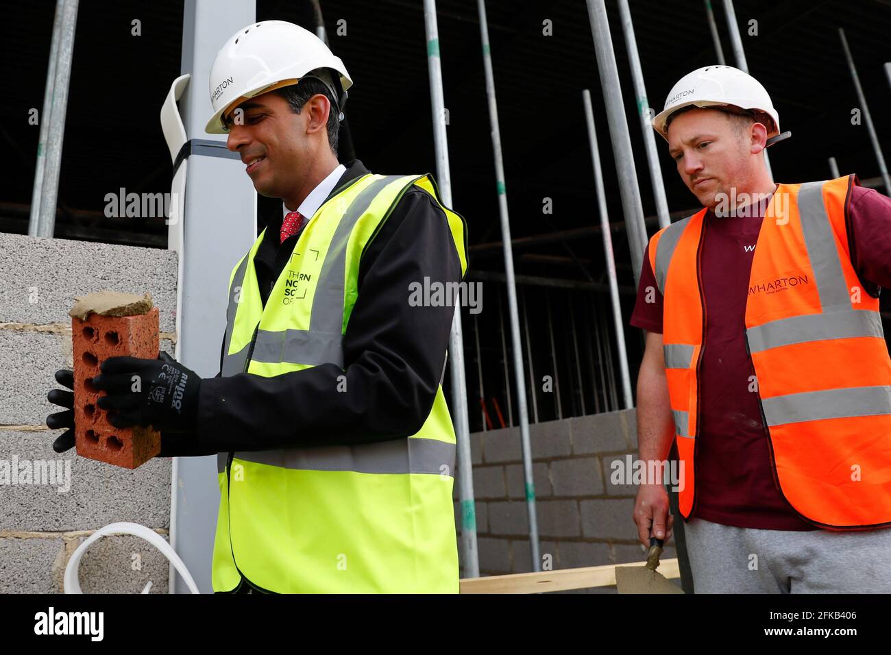 Il Cancelliere dello scacchiere Rishi Sunak tiene un mattone accanto al muratore Danny Honeyman in un'area di costruzione durante una visita elettorale locale alla Northern School of Art di Hartlepool. Data immagine: Venerdì 30 aprile 2021. Foto Stock