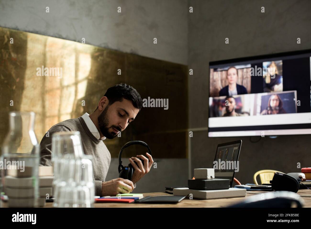 Imprenditore maschile che scrive nel diario alla scrivania durante la riunione videoconferenza Foto Stock