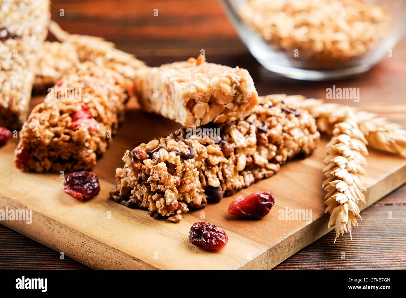 Mazzetto di barrette energetiche a base di muesli senza glutine con frutta secca e vari tipi di noci, fondo in legno. Cibo vegan sano super, diversa dieta fitness sn Foto Stock