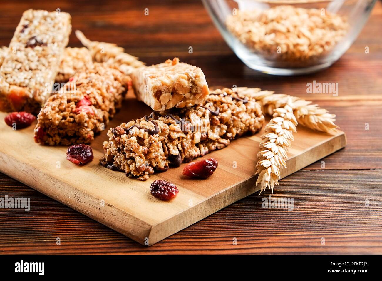 Mazzetto di barrette energetiche a base di muesli senza glutine con frutta secca e vari tipi di noci, fondo in legno. Cibo vegan sano super, diversa dieta fitness sn Foto Stock