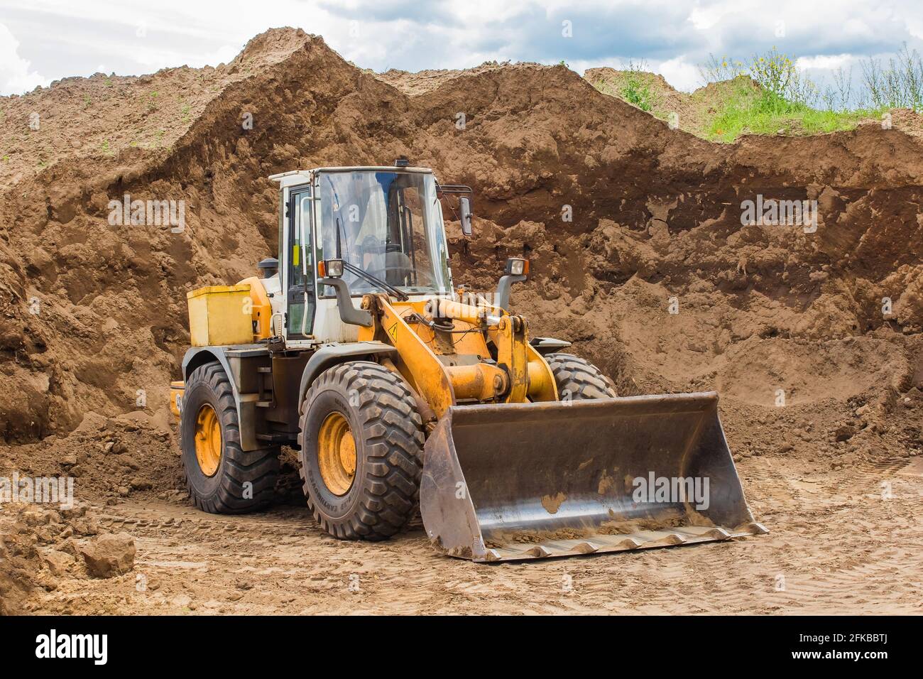 Bielorussia, Minsk - 28 maggio 2020: Bulldozer o trattore industriale pesante macchina in un cantiere sullo sfondo di un grande mucchio di sabbia stuoia Foto Stock