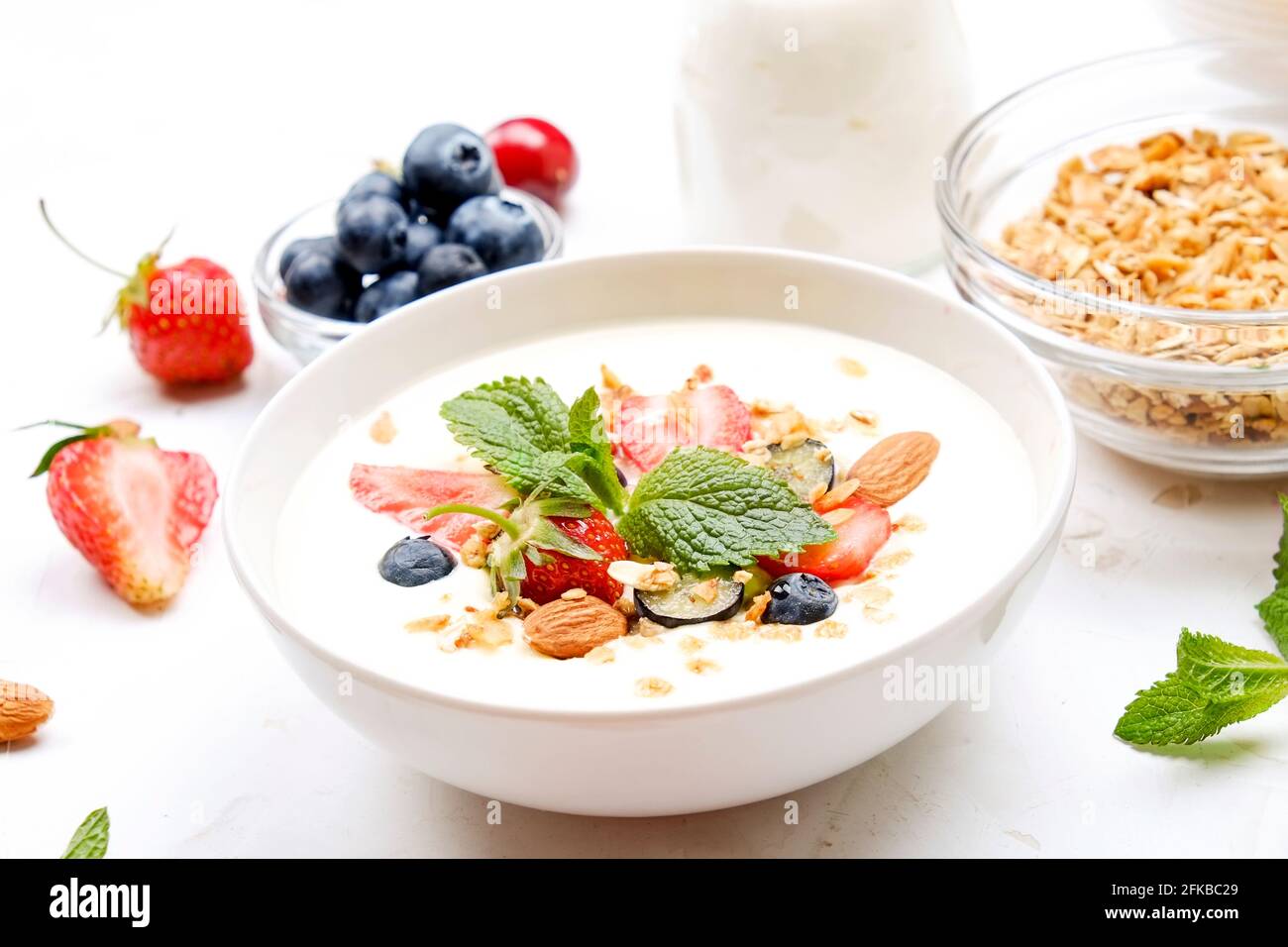 Possibilità di servire una ciotola alla granola con un mix di frutta secca, cereali, frutta e frutti di bosco, yogurt greco. Sana colazione vegetariana, fragola biologica, blueberr Foto Stock