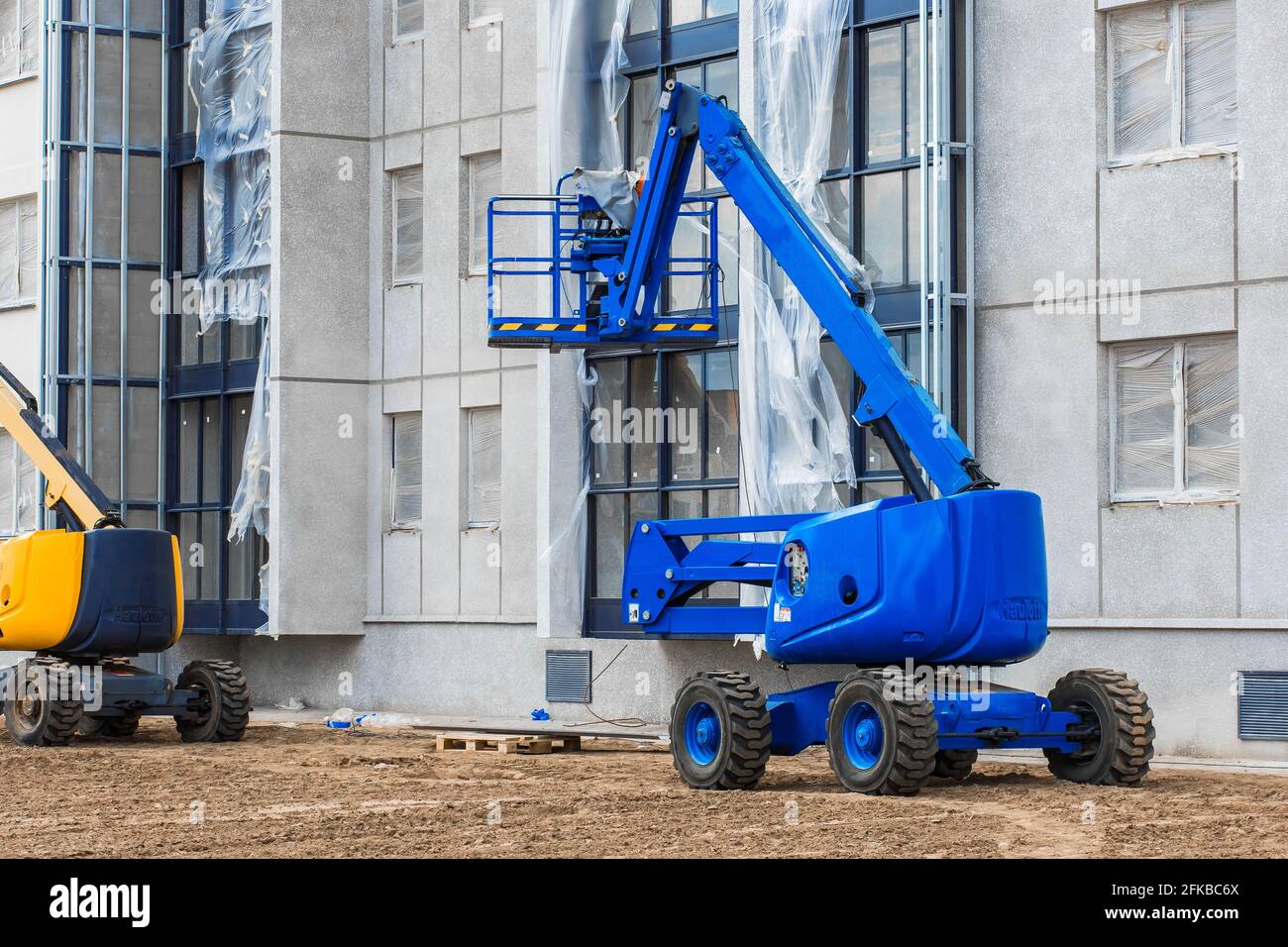 Bielorussia, Minsk - 28 maggio 2020: Veicolo industriale con piattaforma di sollevamento sullo sfondo di un nuovo edificio moderno in costruzione presso una costr Foto Stock