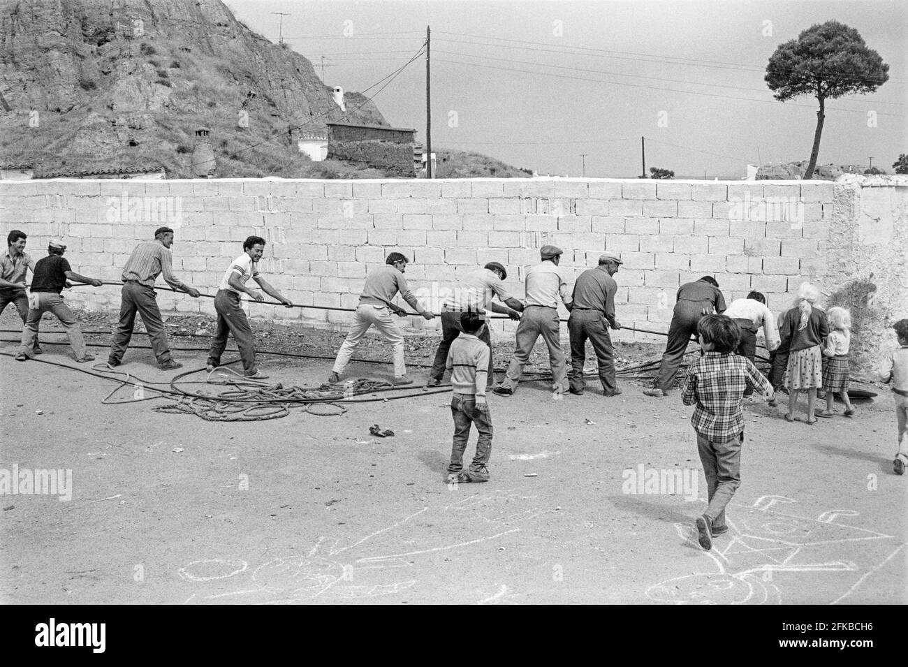 SPAGNA, GUADIX, ANDALUCIA, 1980. Uomini che posano tubi d'acqua nel quartiere delle grotte di Guadix in Andalusia, Spagna meridionale. Foto Copyright: Peter Eastland. Foto Stock