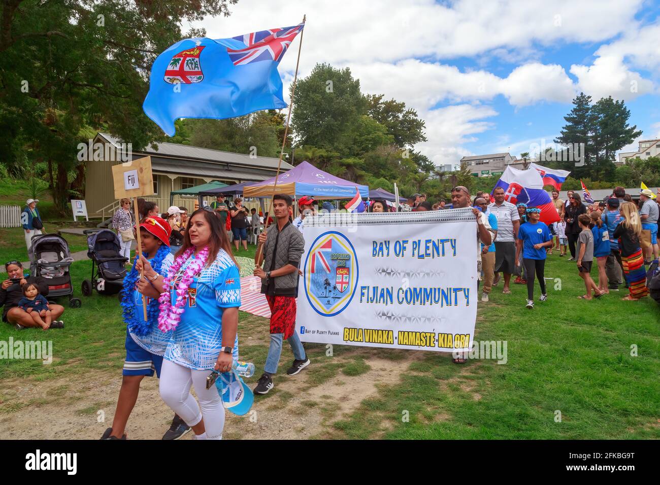 Le Fiji marciano con una bandiera e la bandiera delle Fiji in un festival multiculturale. Tauranga, Nuova Zelanda Foto Stock