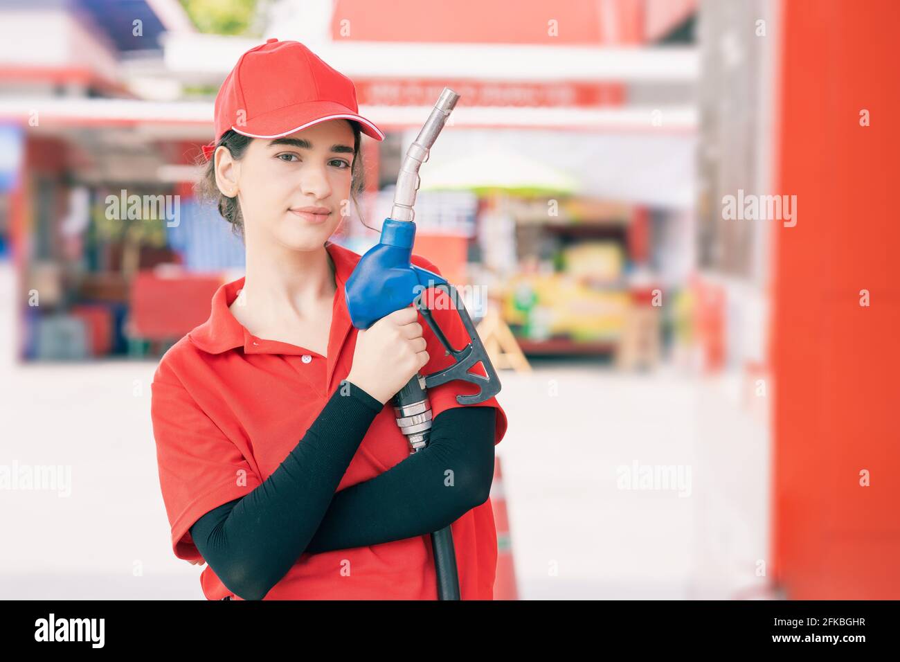 Ritratto gas stazione di lavoro donne di lavoro felice sorridente con ugello carburante per auto benzina rifornimento di lavoro di servizio. Foto Stock