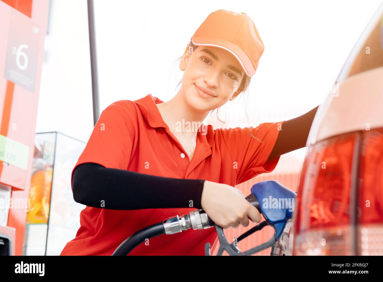 Stazione di benzina donne lavoratori dipendenti felice servizio di lavoro ricarica auto benzina per il viaggiatore Foto Stock