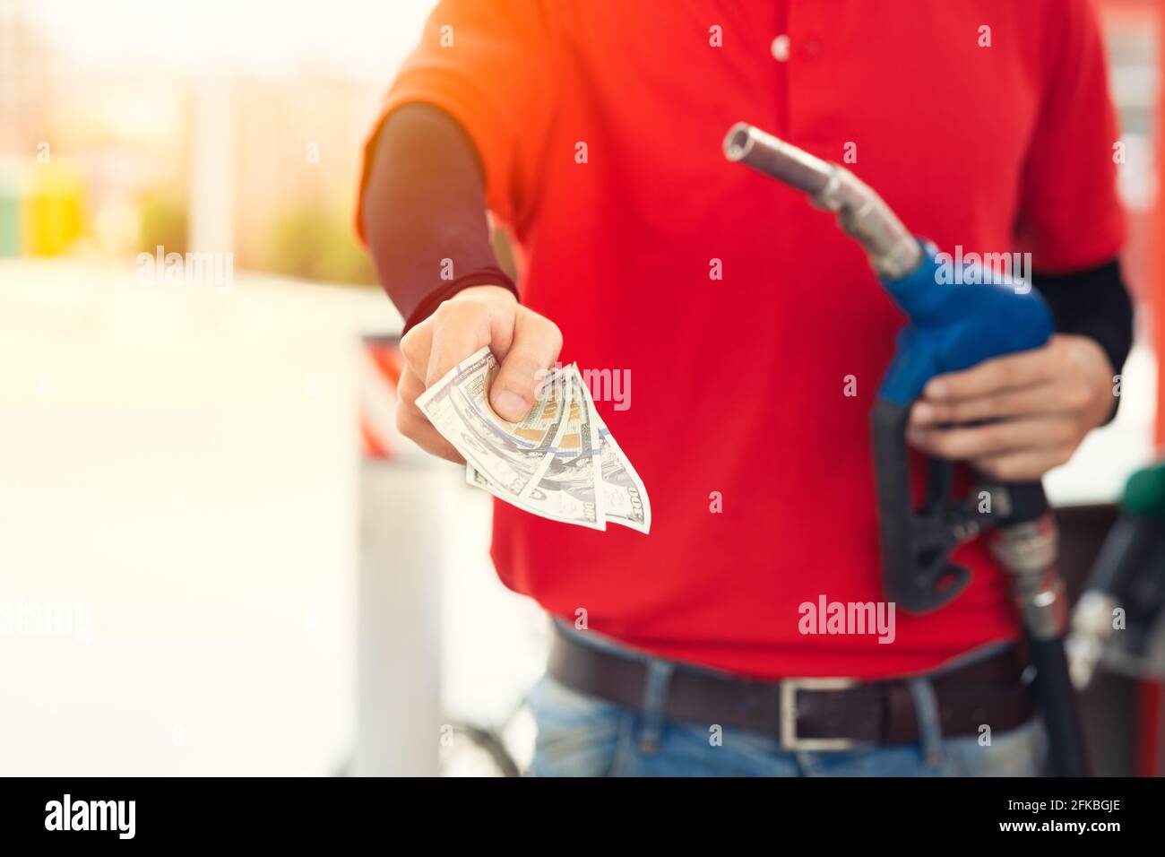 Il lavoratore del personale della stazione di servizio restituisce il denaro per un prezzo del carburante più basso, riduzione dei costi del gas, riduzione del prezzo di caduta della benzina di risparmio e concetto di rimborso in contanti Foto Stock