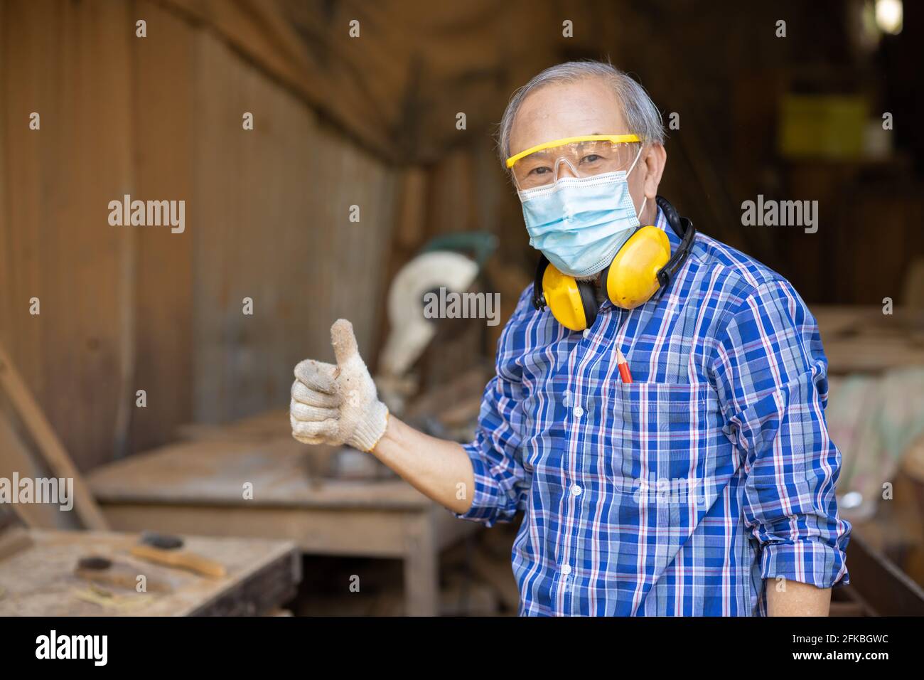 Ritratto di hobby di lavoro di legno anziano per il buon pensionamento, uomo asiatico maturo maestro professionale di legno artigianato mobili uomo produttore di legno. Foto Stock