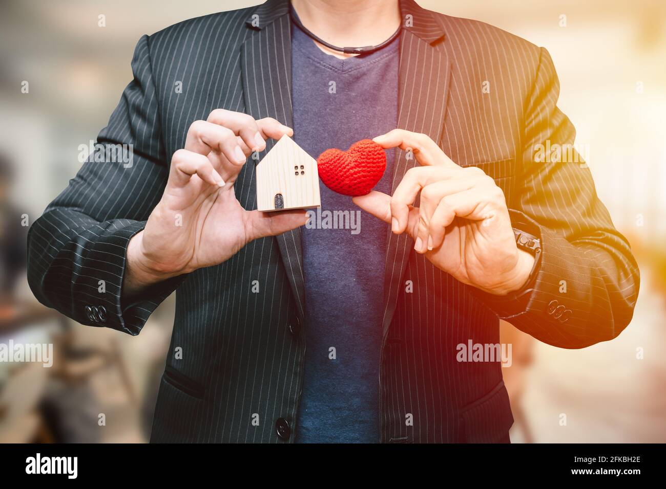 uomo maschio mano che tiene piccola casa e segno hart per love casa o business alloggio concetto di servizio Foto Stock