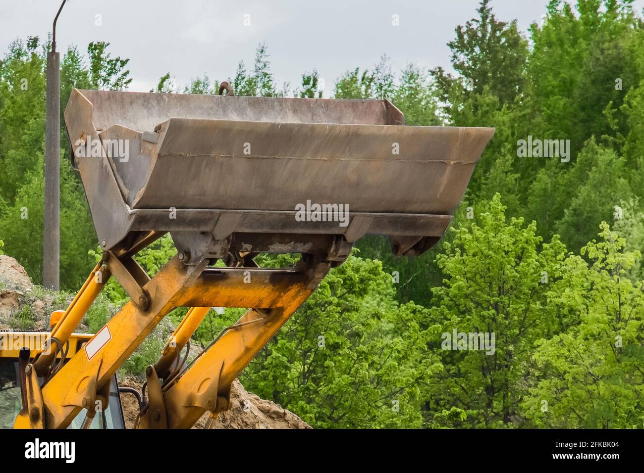 Apripista industriale o pala caricatrice con benna sollevata in cantiere. Foto Stock