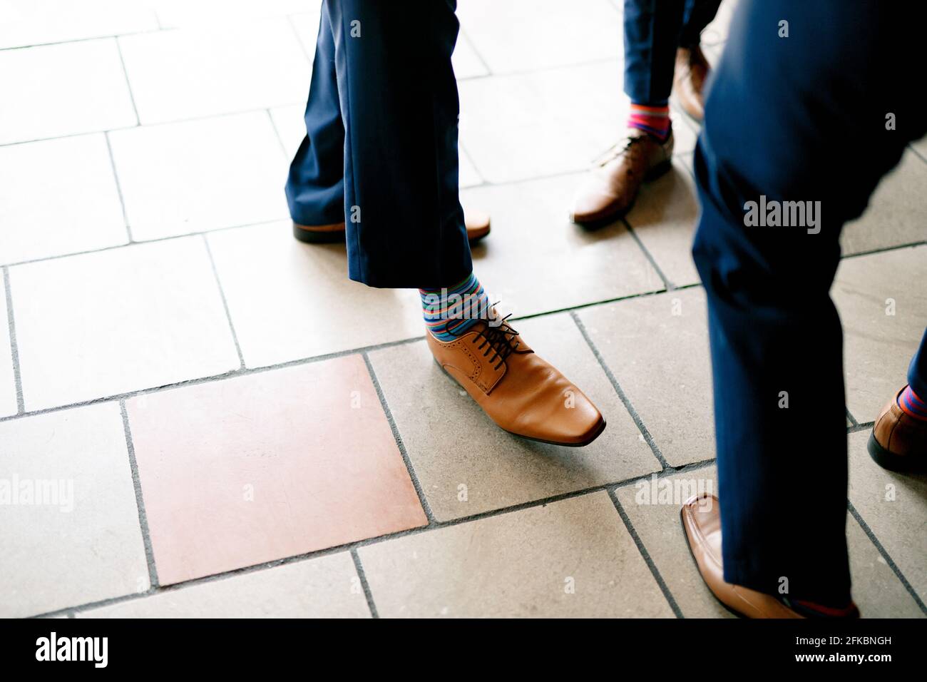 Gambe di uomini in pantaloni blu, scarpe in pelle e calze colorate a righe  luminose, i testimoni dello sposo prima del matrimonio Foto stock - Alamy