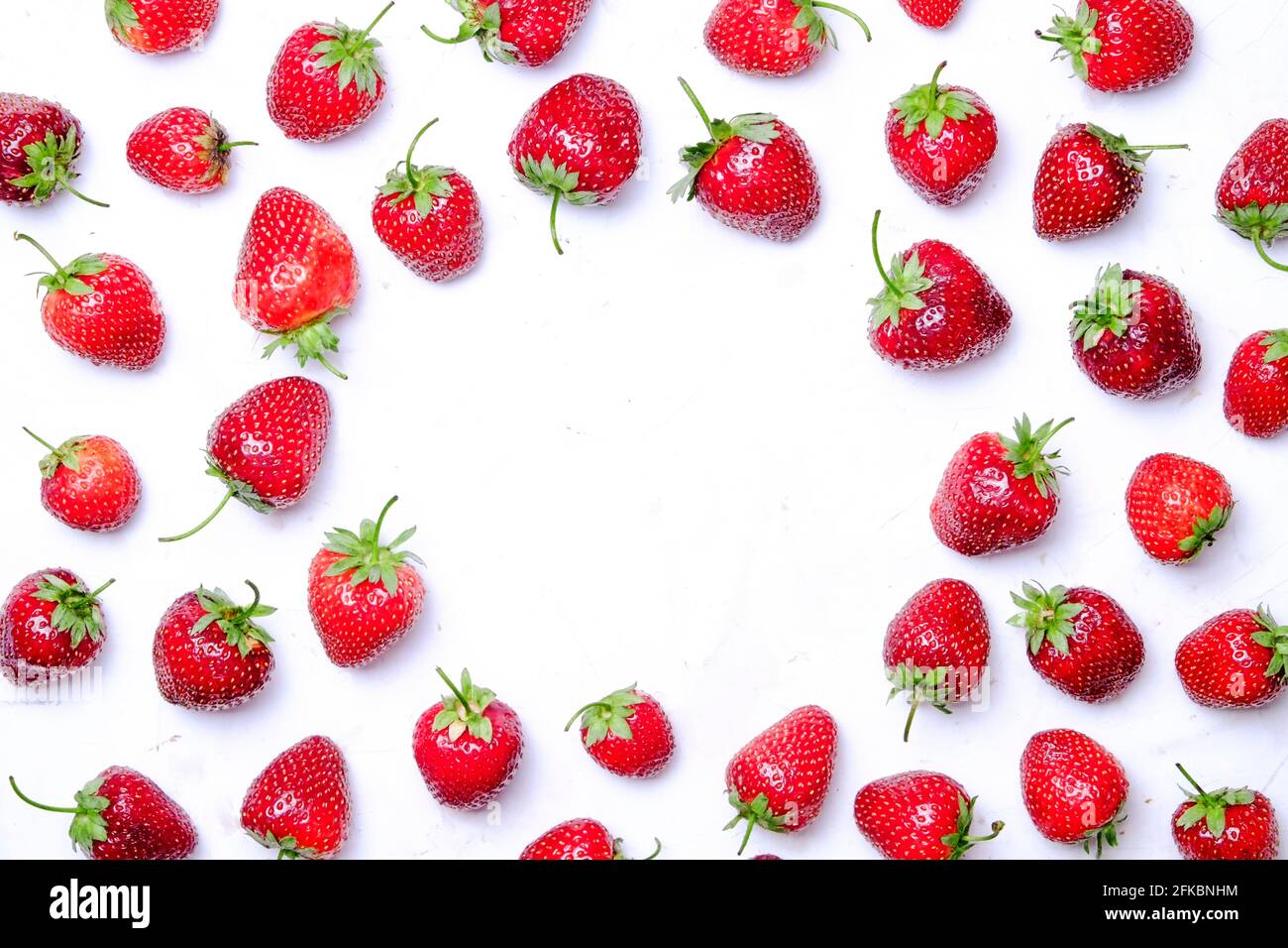 Mazzo di fragole biologiche fresche con motivo ornamentale circolare senza cuciture, sfondo bianco. Concetto di cibo pulito. Sano nutriente vegan crudo di Foto Stock