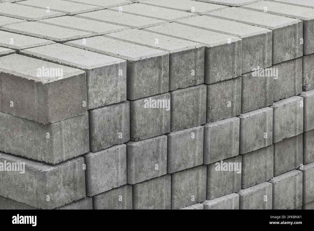 Una pila di lastre di pietra per pavimentazione impaccate di materiali per marciapiedi industriali in un cantiere. Foto Stock