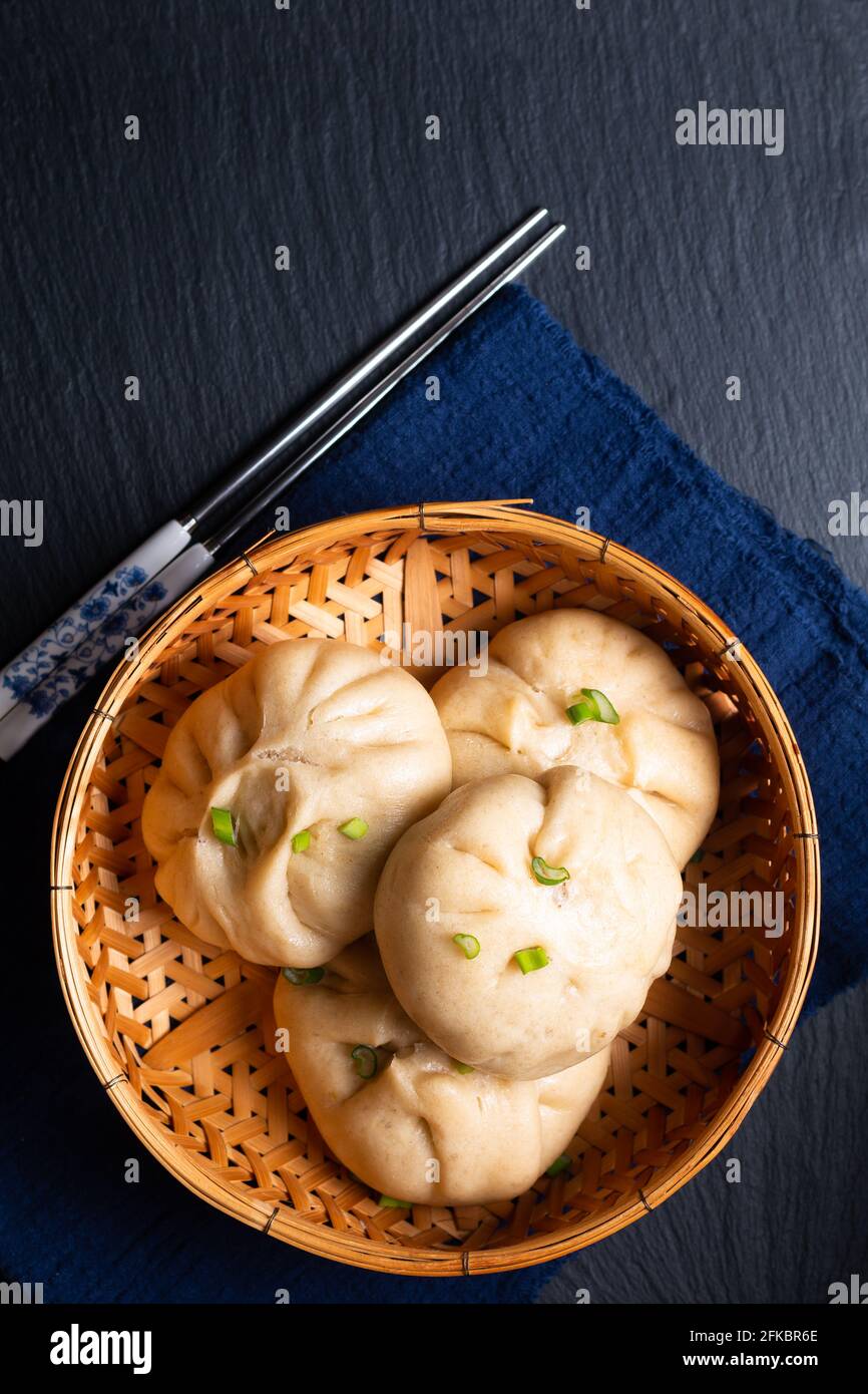 Concetto di cibo punto fuoco fatto in casa dim sum Baozi biologico, o bao maiale cinese al vapore Buns su sfondo nero con spazio di copia Foto Stock